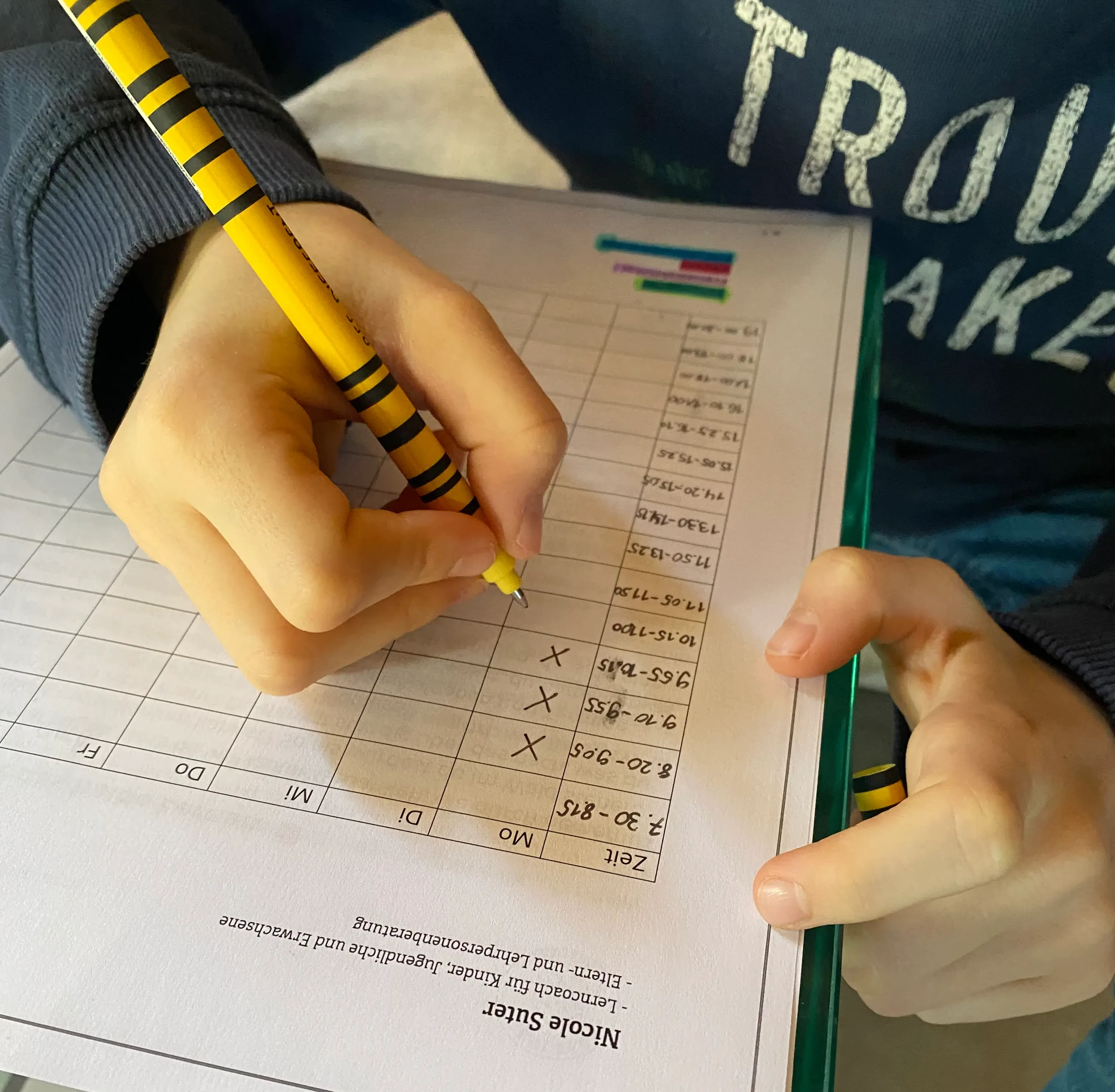 Kind füllt Lernblatt aus